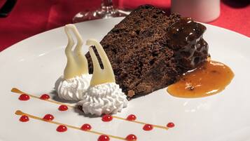 A dessert plate with a chocolate cake, whipped cream, and caramel sauce.