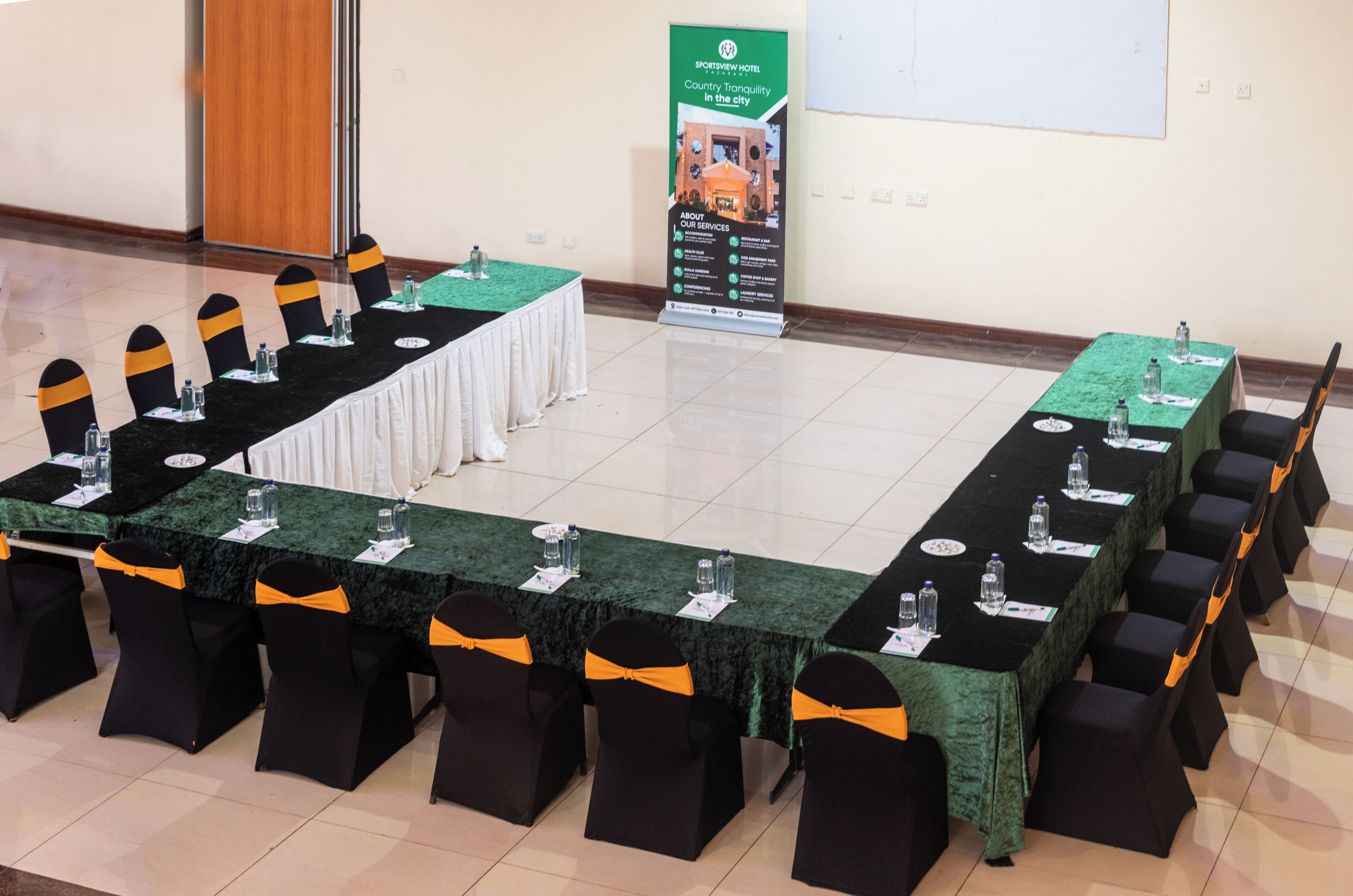 A conference room with a long table, chairs, and a banner.