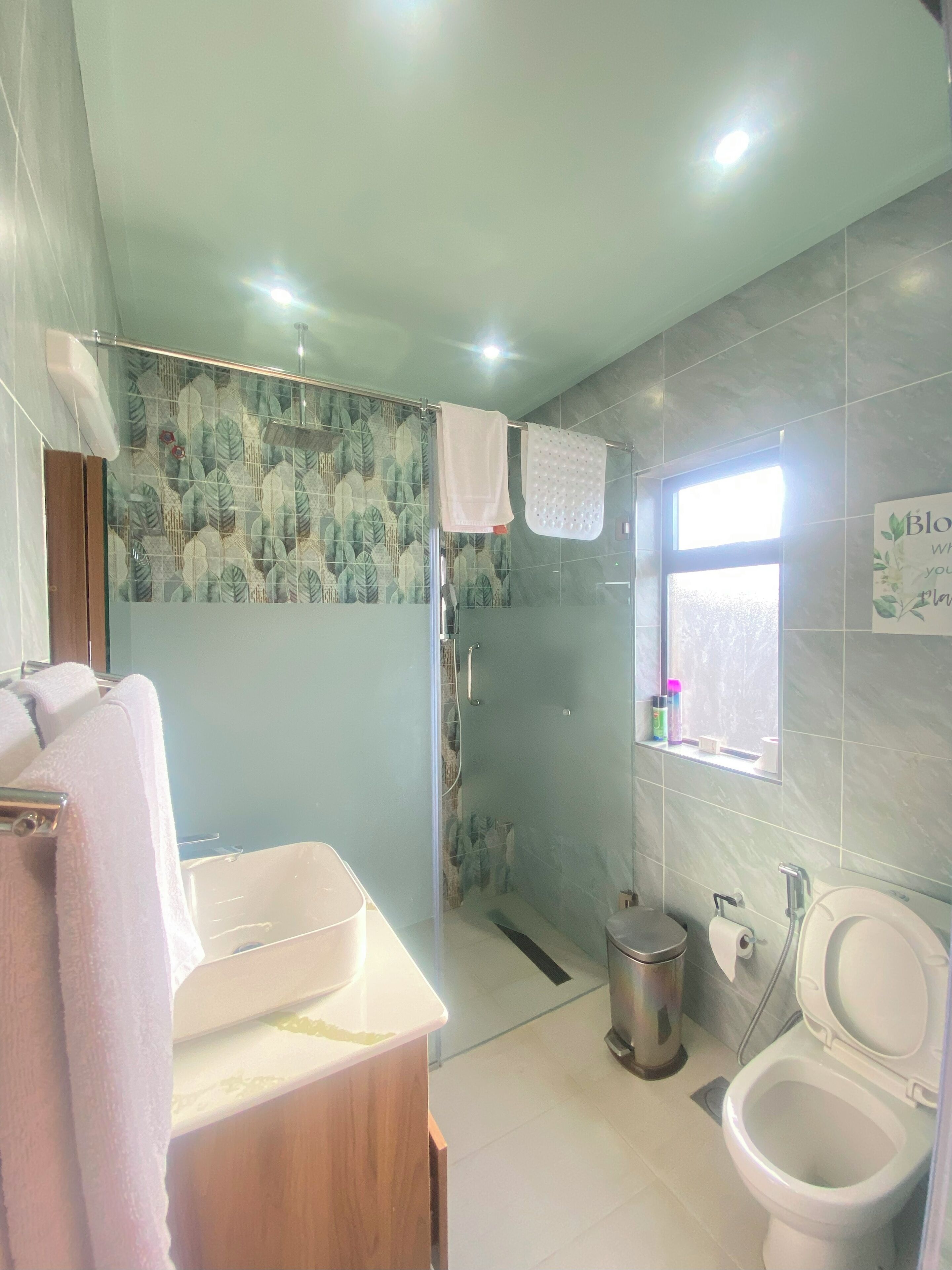 A bathroom with a shower, toilet, and sink.