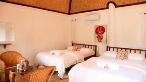 A room with two beds, a wicker chair, a small table with a kettle, and a ceiling with a woven pattern. - SunzEn Palawan, Resort (Sunz En Coron Resort) (Coron)
