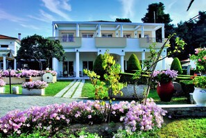 Un immeuble de deux étages avec un jardin à l’avant.