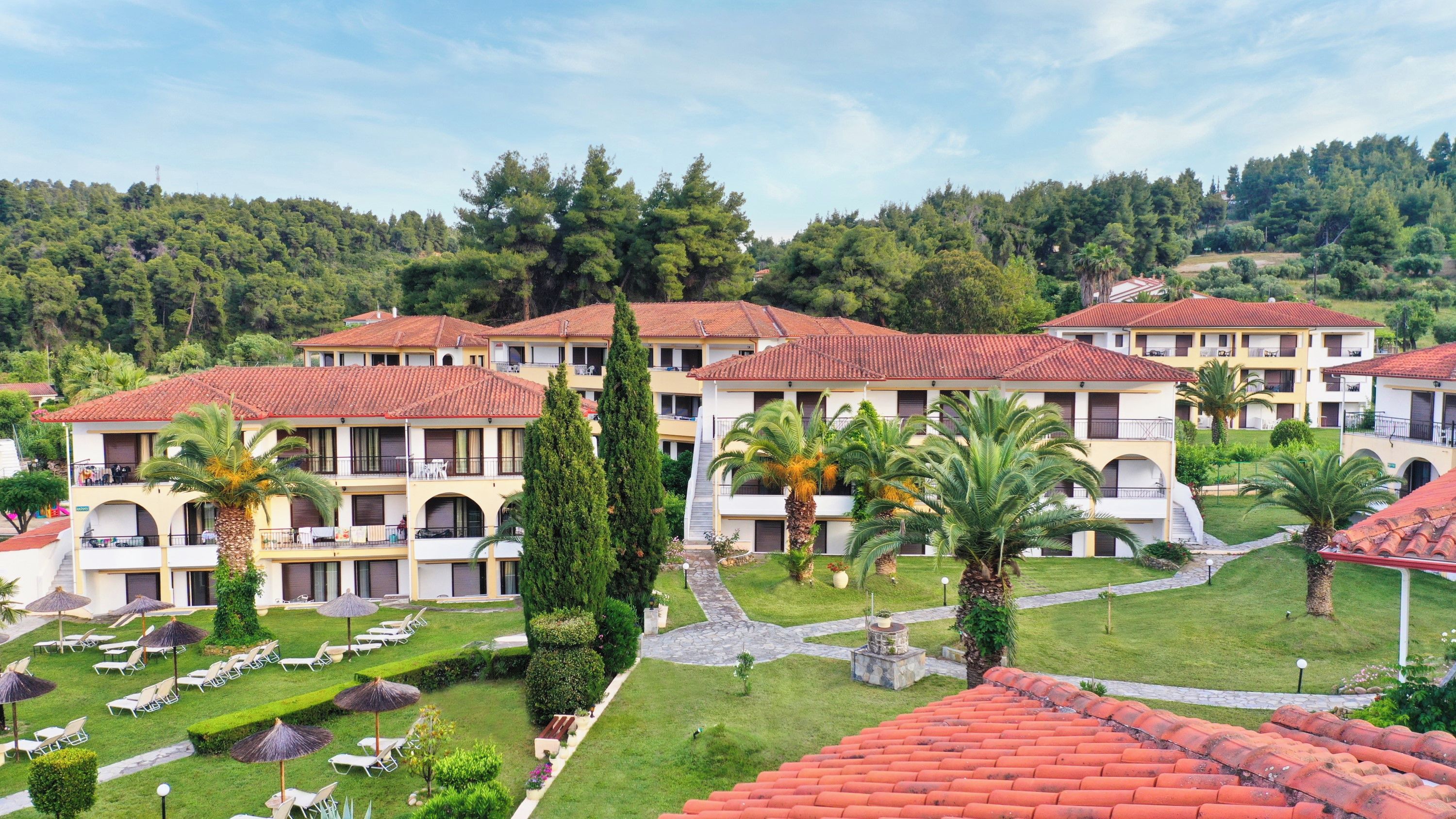 Ein Hotel mit mehrstöckigen Gebäuden, Außenbereichen und einem gepflegten Garten.
