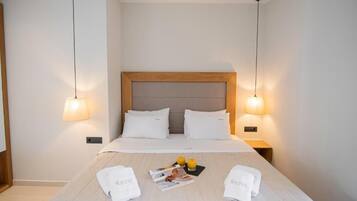 Una habitación de hotel con una cama bien hecha, dos lámparas de noche y una revista sobre la cama.
