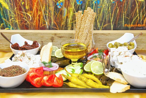 A variety of food items including olives, bread, and a bowl of oil. - Chrousso Village (Kassandra)