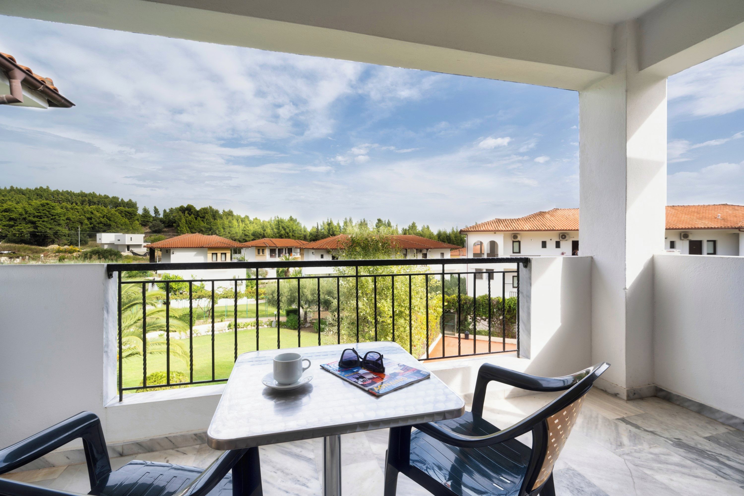 Ein Balkon mit Tisch, Stühlen und einer Sonnenbrille.