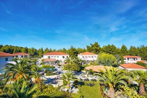 Un resort con varias construcciones, piscina y abundante vegetación.