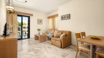 A modern living room with a sofa, a dining table with chairs, a TV, and a balcony with a table and chairs.