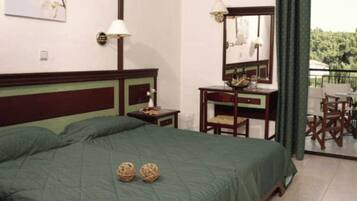 Un dormitorio con cama, mesita de noche, cómoda, espejo y vistas al exterior.