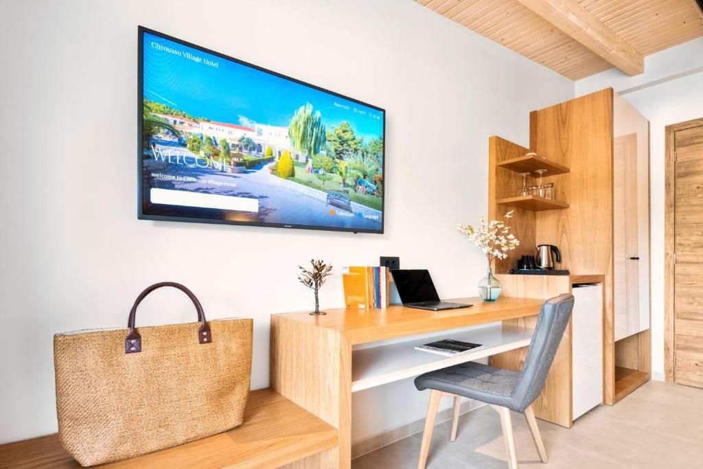 Een moderne kamer met een bureau, stoel en een televisie waarop een welkomstbericht staat.