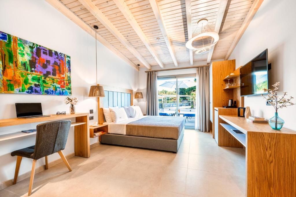 Ein modernes Hotelzimmer mit Bett, Schreibtisch und Fernseher.