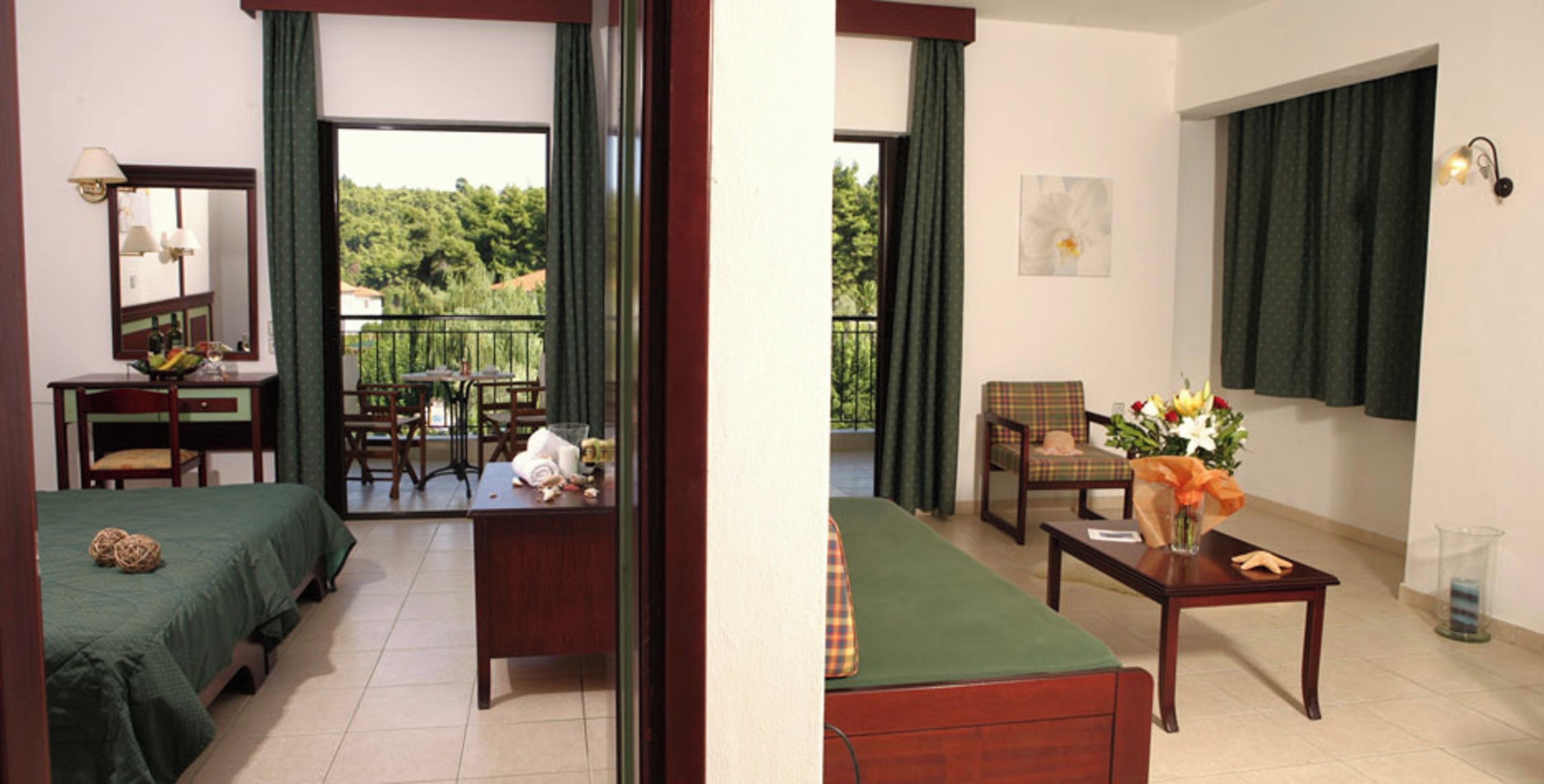 A hotel room with a balcony, a dining area, and a living space.