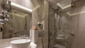 A modern bathroom with a large white sink, a toilet, and a glass-enclosed shower area. - Chrousso Village (Kassandra)