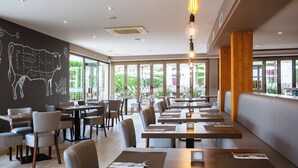 A restaurant with long tables, chairs, and a mural of a cow on the wall. - BQ Can Picafort Hotel (Santa Margalida)