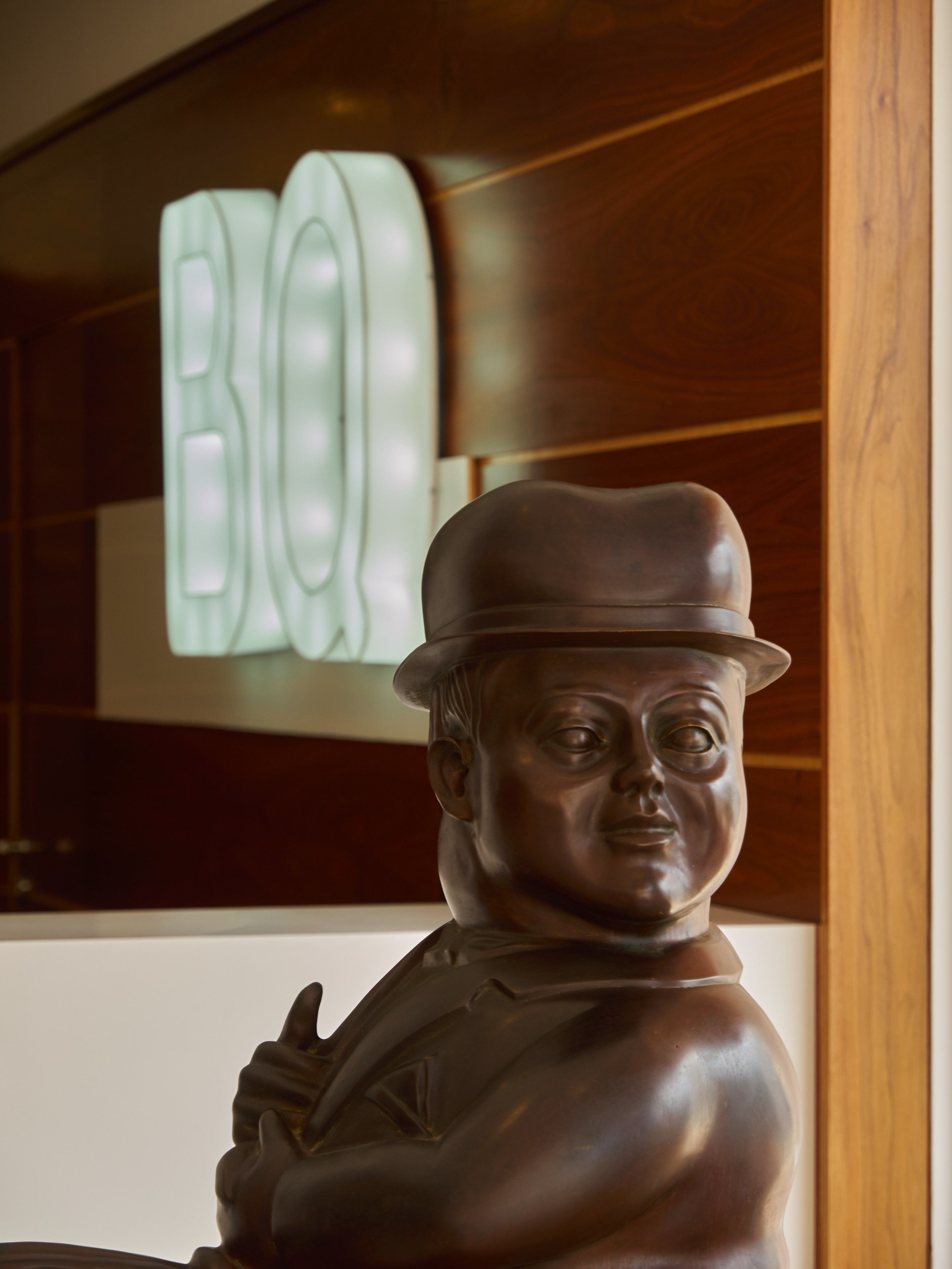 A statue of a man with a hat and a thumbs-up gesture.