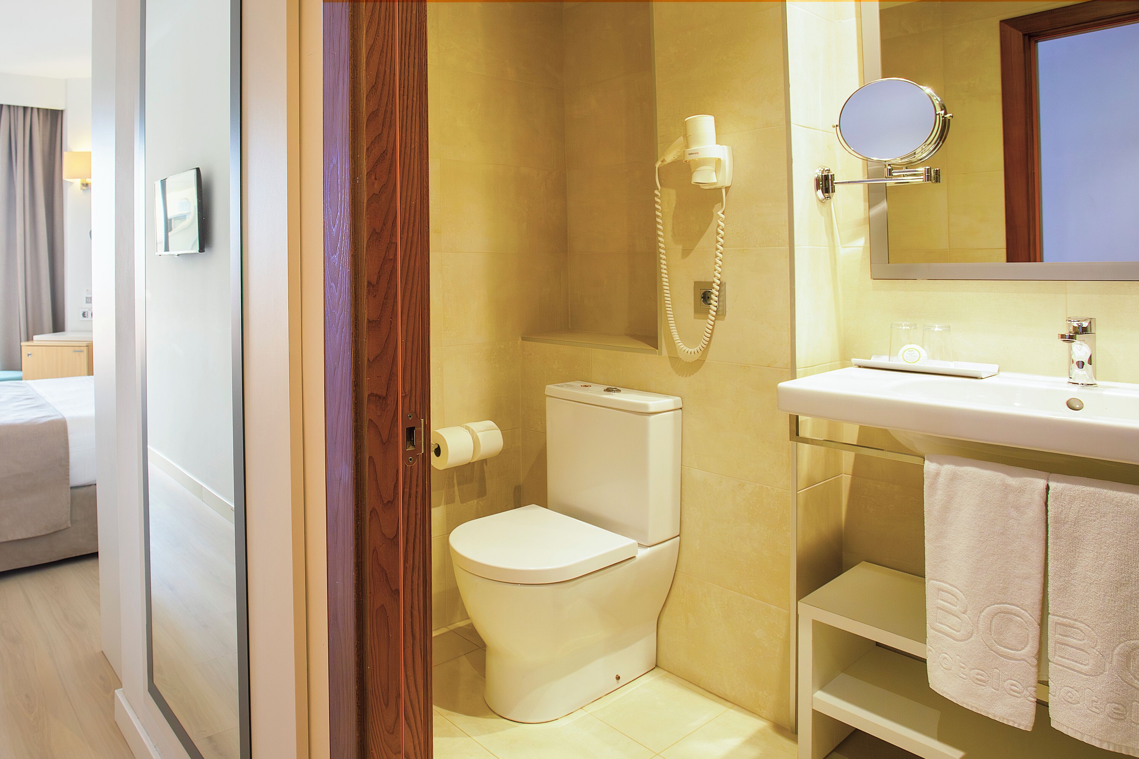 Un baño con inodoro, lavabo, espejo y ducha.