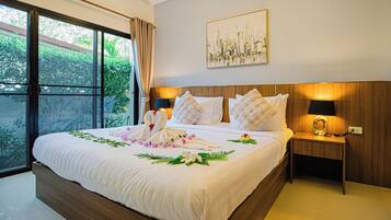 A neatly made bed with floral decorations, a cityscape painting, and a nightstand with a lamp.