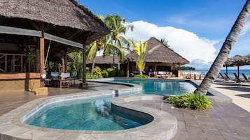 Een buitenzwembad, ligstoelen bij het zwembad