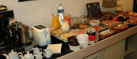 Un bufé con diversos alimentos, una cafetera y un tostador.