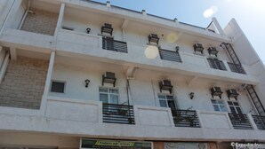 Un edificio de varios pisos con balcones, unidades de aire acondicionado y un letrero que dice 'Products and Services'.