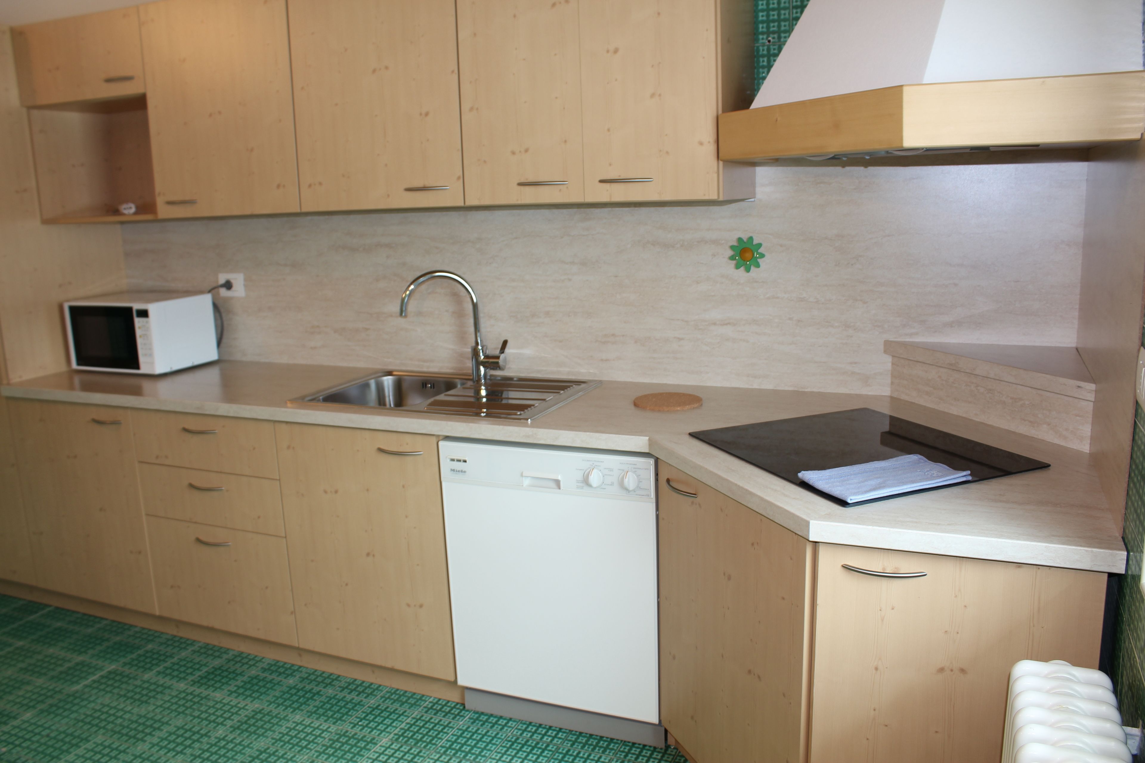 A kitchen with wooden cabinets, a dishwasher, a microwave, and a sink.