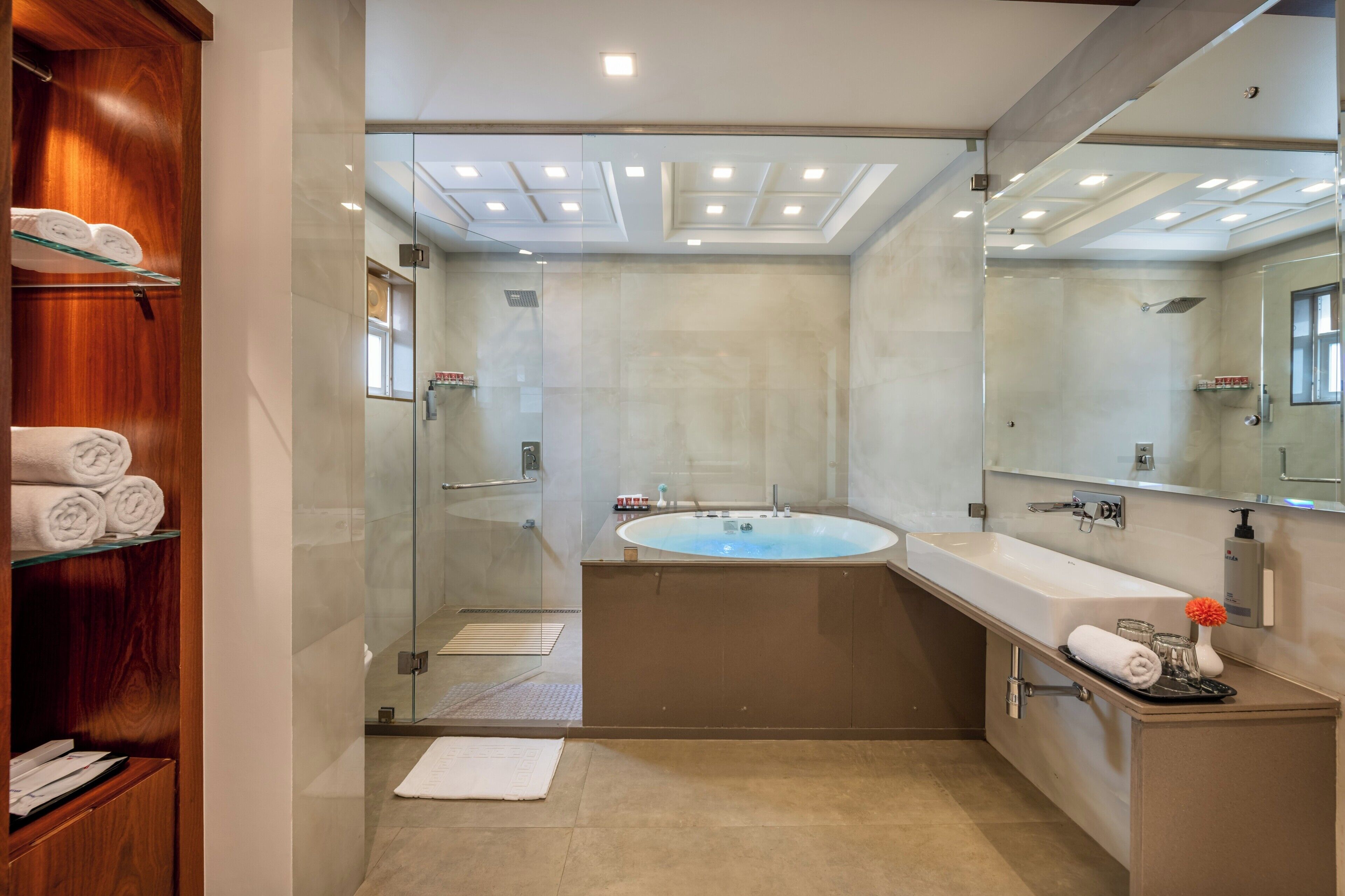 A modern bathroom with a glass-enclosed shower, a freestanding bathtub, and a vanity with a mirror.
