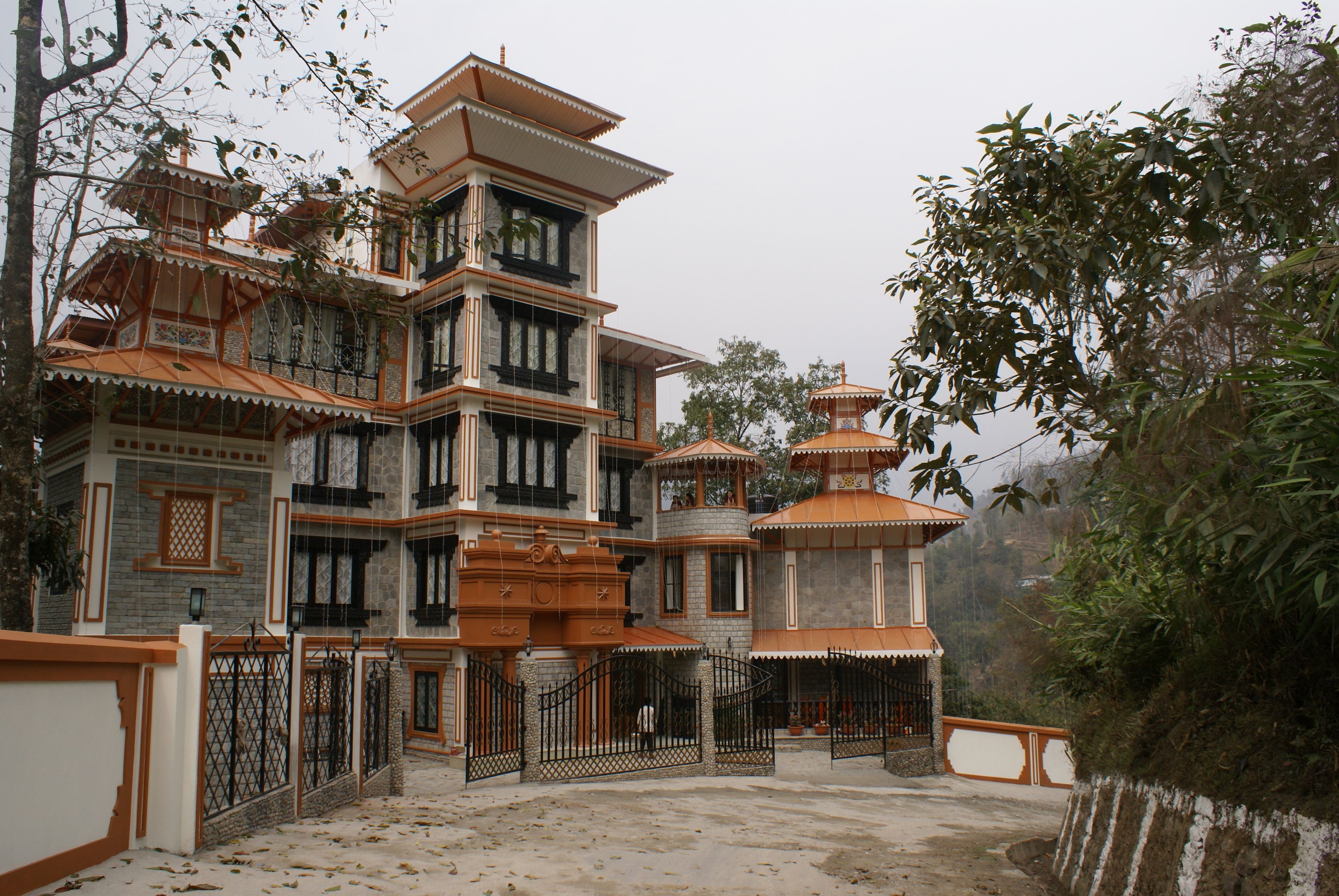 A multi-story building with a traditional architectural style, featuring multiple balconies and a gated entrance.
