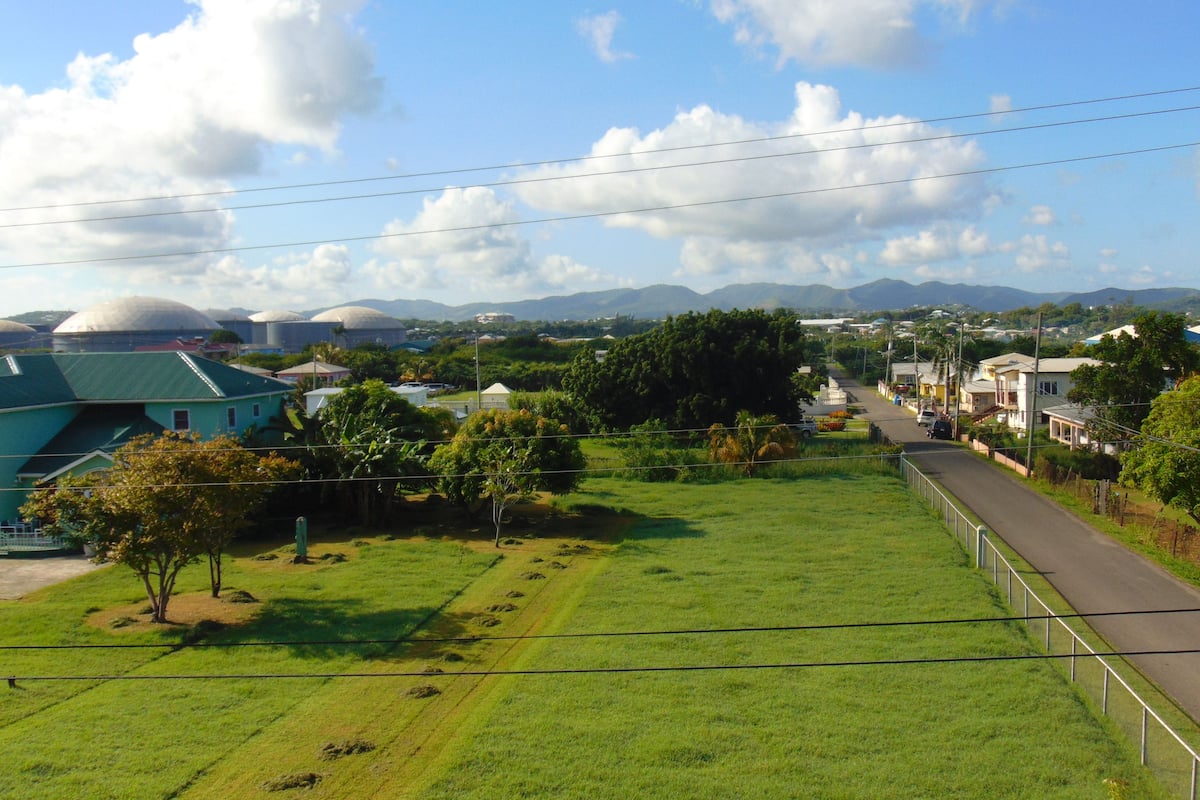 A residential area with houses, a road, and a green field.