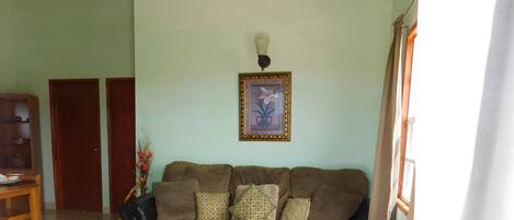 A living room with a brown sofa, a wooden coffee table, and a framed picture on the wall.