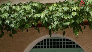 A green door with a window, a white lantern on a table, and two green chairs. - Subretia Residenze di Campagna (Montefalco)