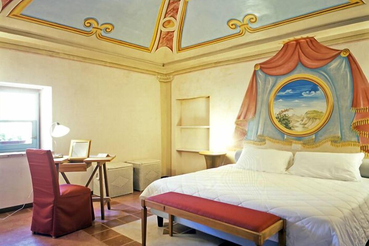 Une chambre d’hôtel avec un grand lit, un bureau et une chaise.