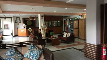 A hotel lobby with a reception desk, seating area, and a store named 'Bugsnack Room'.