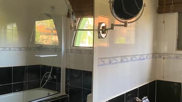 Een badkamer met een bad, een wastafel, een spiegel en een raam.
