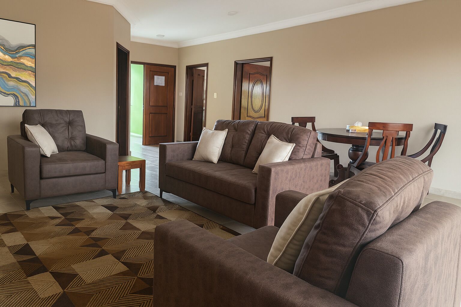 Una sala de estar con un sofá marrón, un sillón marrón y una alfombra estampada.