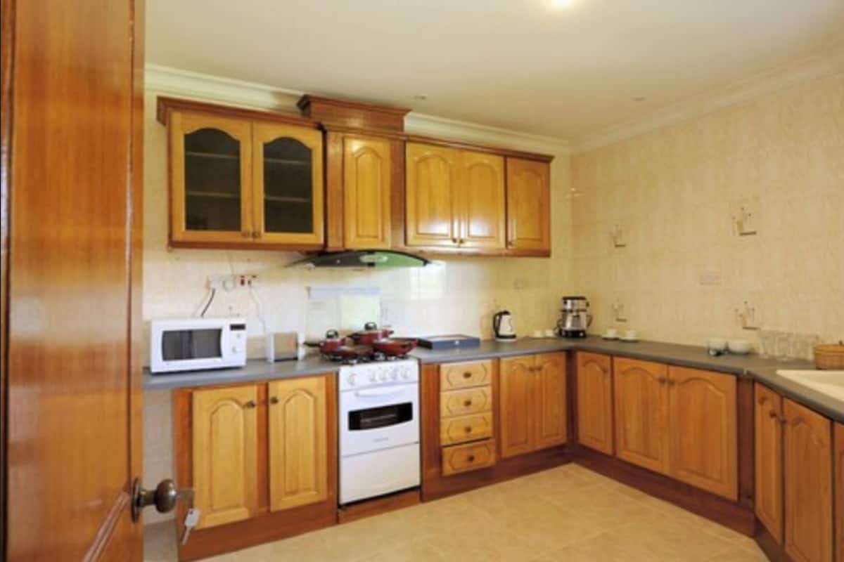 Frigorífico grande, microondas, cafetera o tetera y mesa de comedor