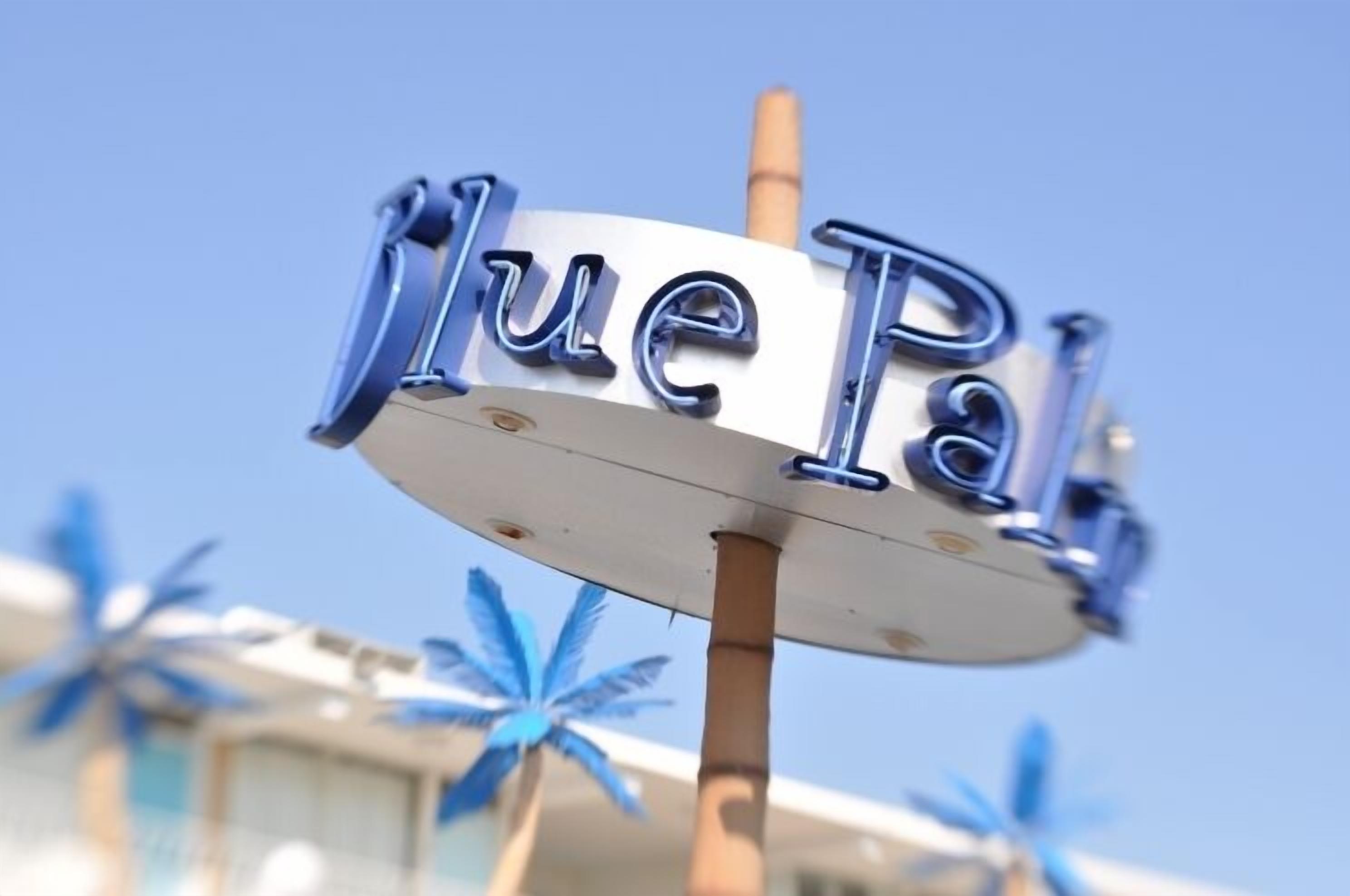 A sign with the text "Blue Pal" on a pole.