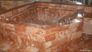 A large, rectangular marble bathtub with a built-in showerhead and two faucets. - Halina Drive Inn Hotel - Pasay (Pasay)