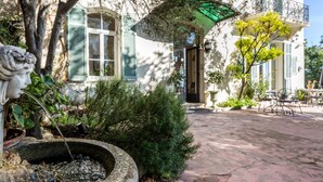 A courtyard with a fountain, a statue, and a building with a balcony. - Logis hôtel la Bellaudière (Grasse)
