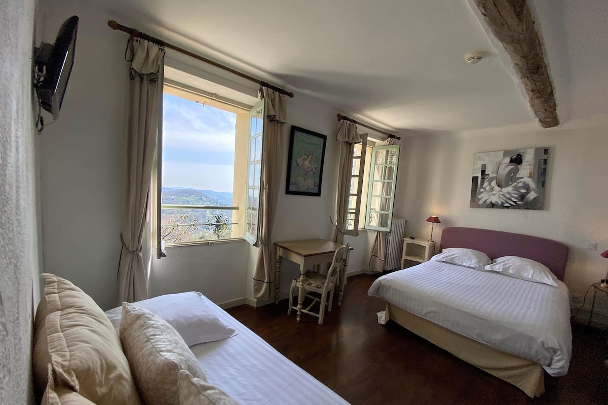 A bedroom with two beds, a desk, and a chair.