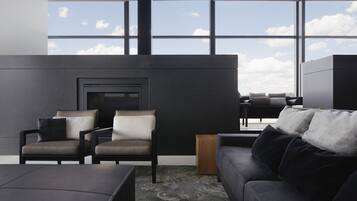 A modern living room with a fireplace, two armchairs, a sofa, and a coffee table.