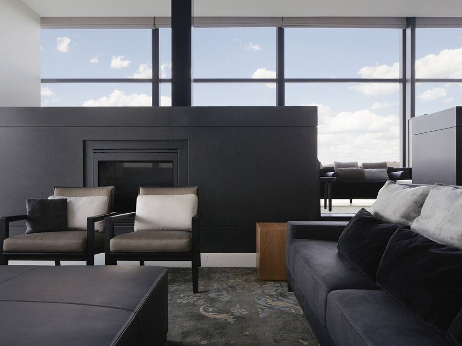 A modern living room with a fireplace, two armchairs, a sofa, and a coffee table.