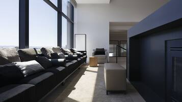 A modern living room with a sofa, a coffee table, and a fireplace.
