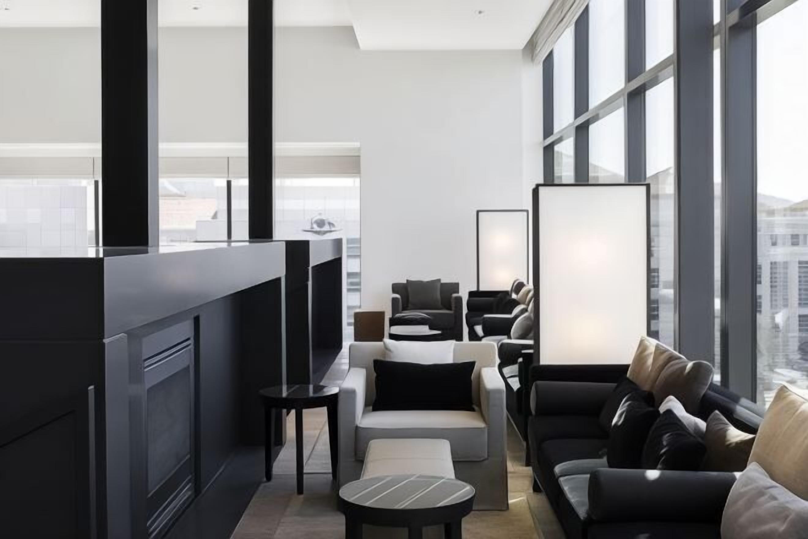 A modern interior with a seating area, large windows, and a view of the city.