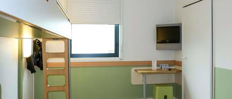 Una habitación pequeña con cama, una ventana, televisor y un taburete verde.