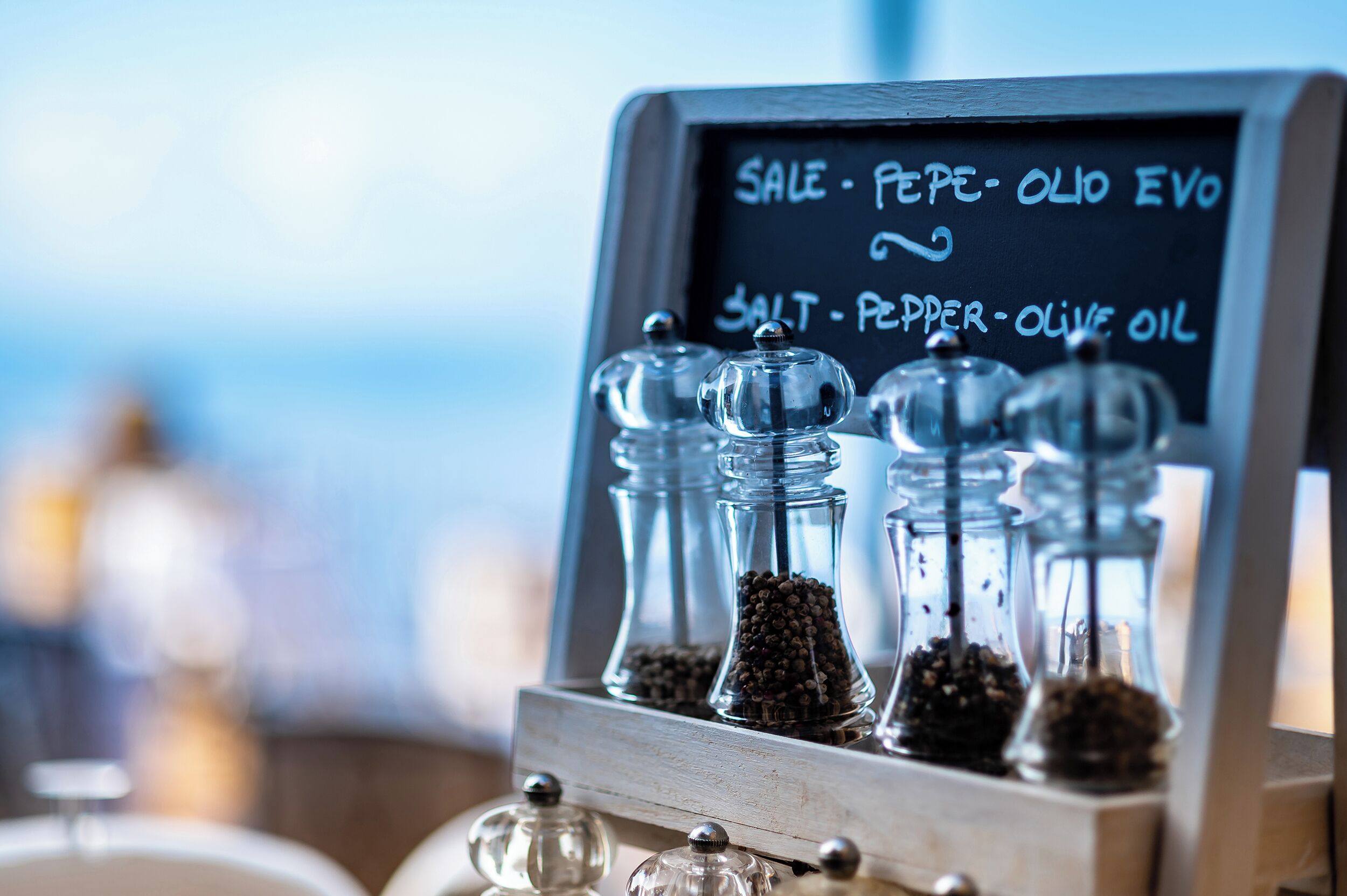 Pizarra con menú que incluye artículos como 'OFERTA - PIMIENTA - ACEITE EVO' y 'SAL - PIMIENTA - ACEITE DE OLIVA'.