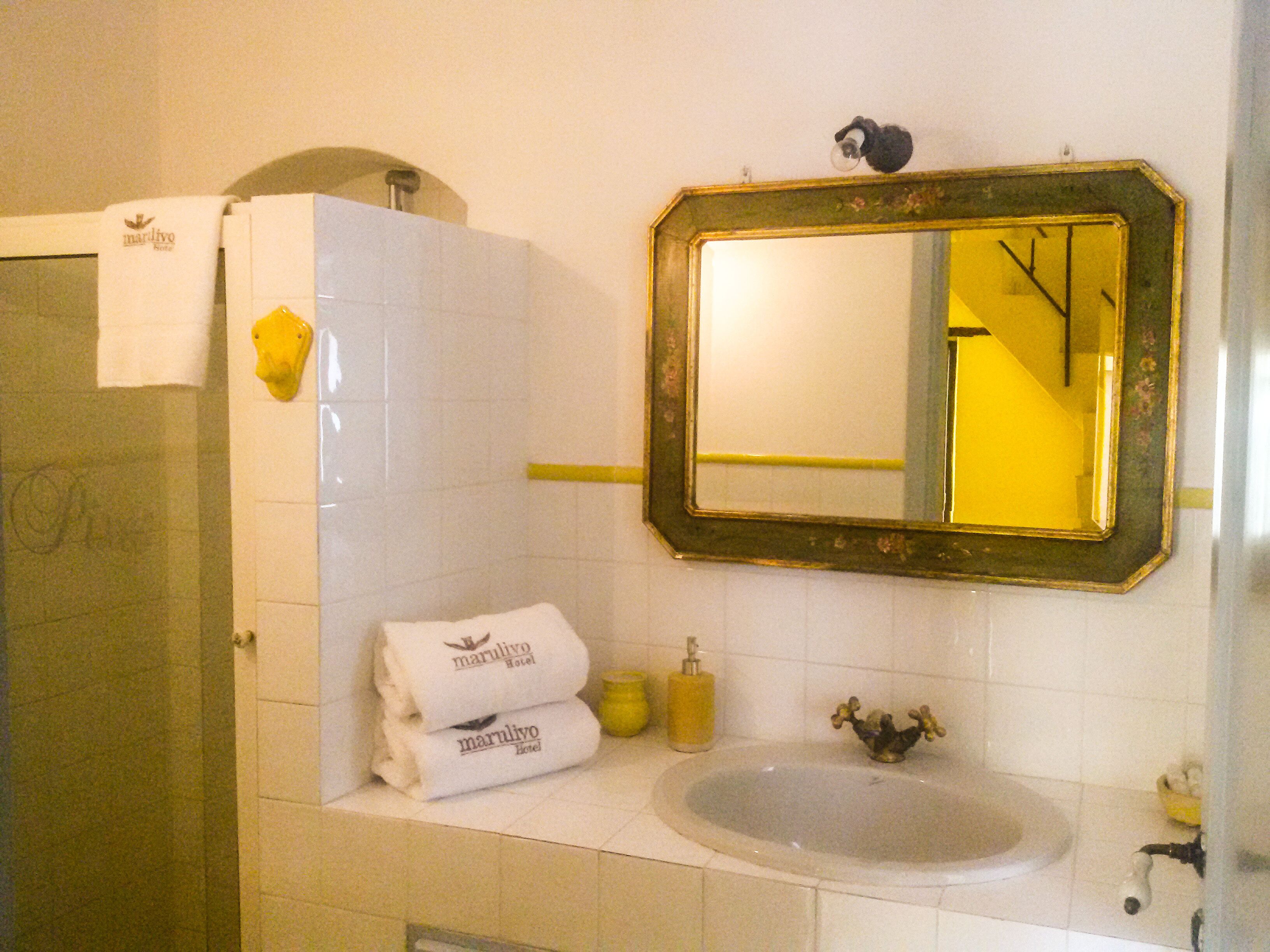 Une salle de bain avec un lavabo, un miroir et des serviettes.