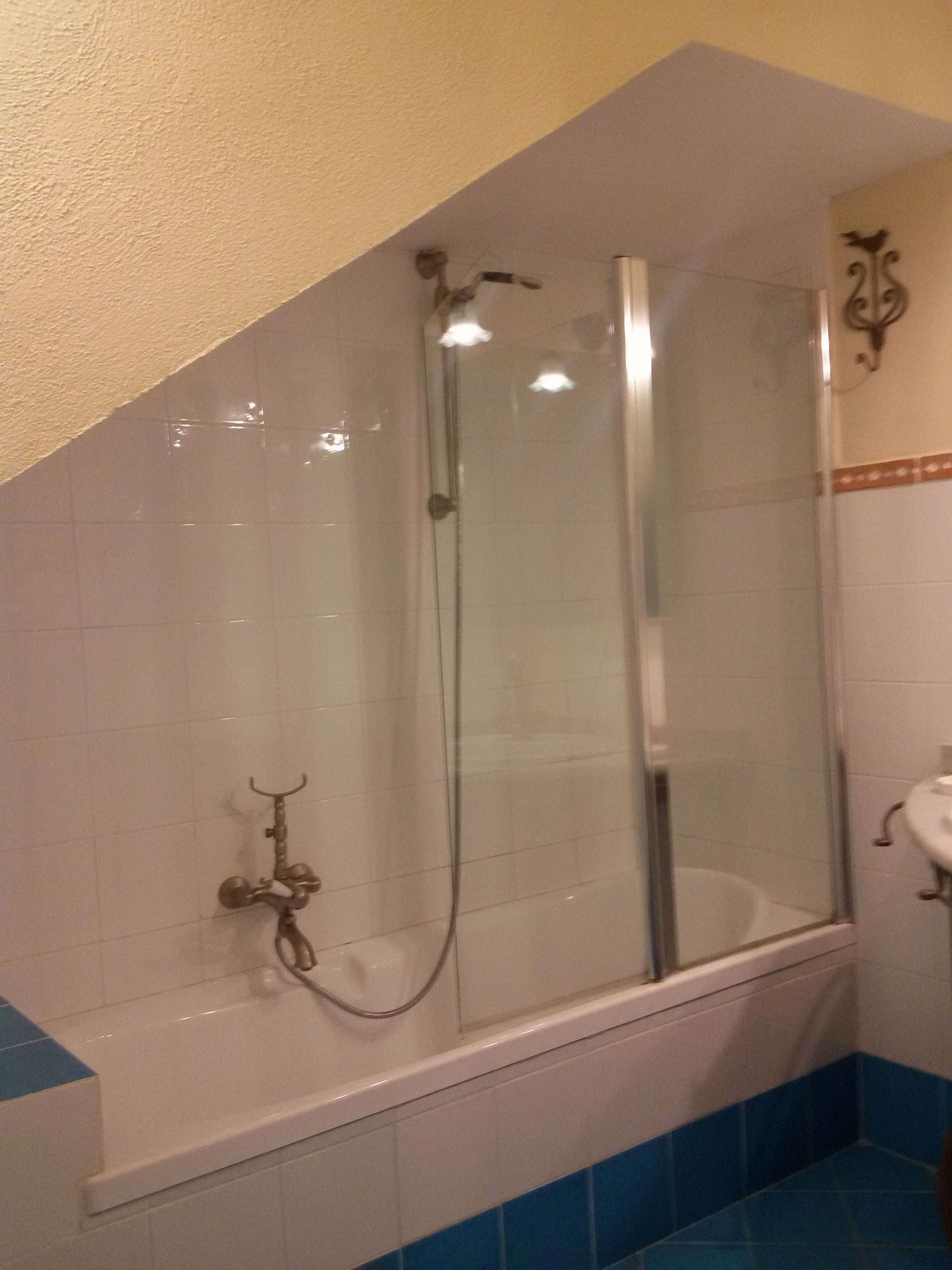 Un baño con ducha de vidrio, bañera y lavamanos blanco.