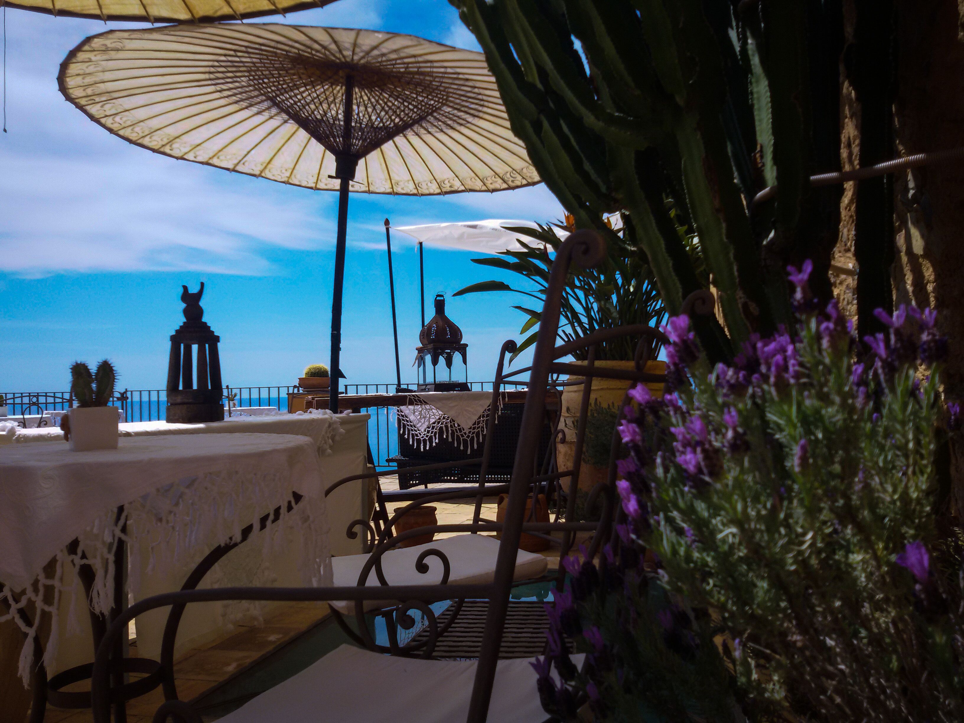 An outdoor seating area with tables and chairs, umbrellas, and decorative items.