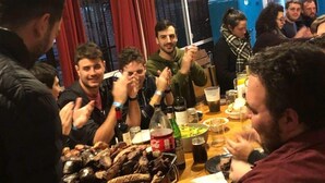 A group of people around a table with food and drinks, in a room with a window and curtains. - Gorilla - Hostel (Mendoza)