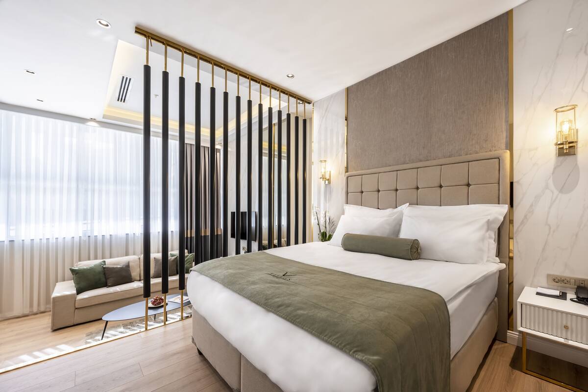 Un dormitorio moderno con una cama grande, un sofá y una mesita.