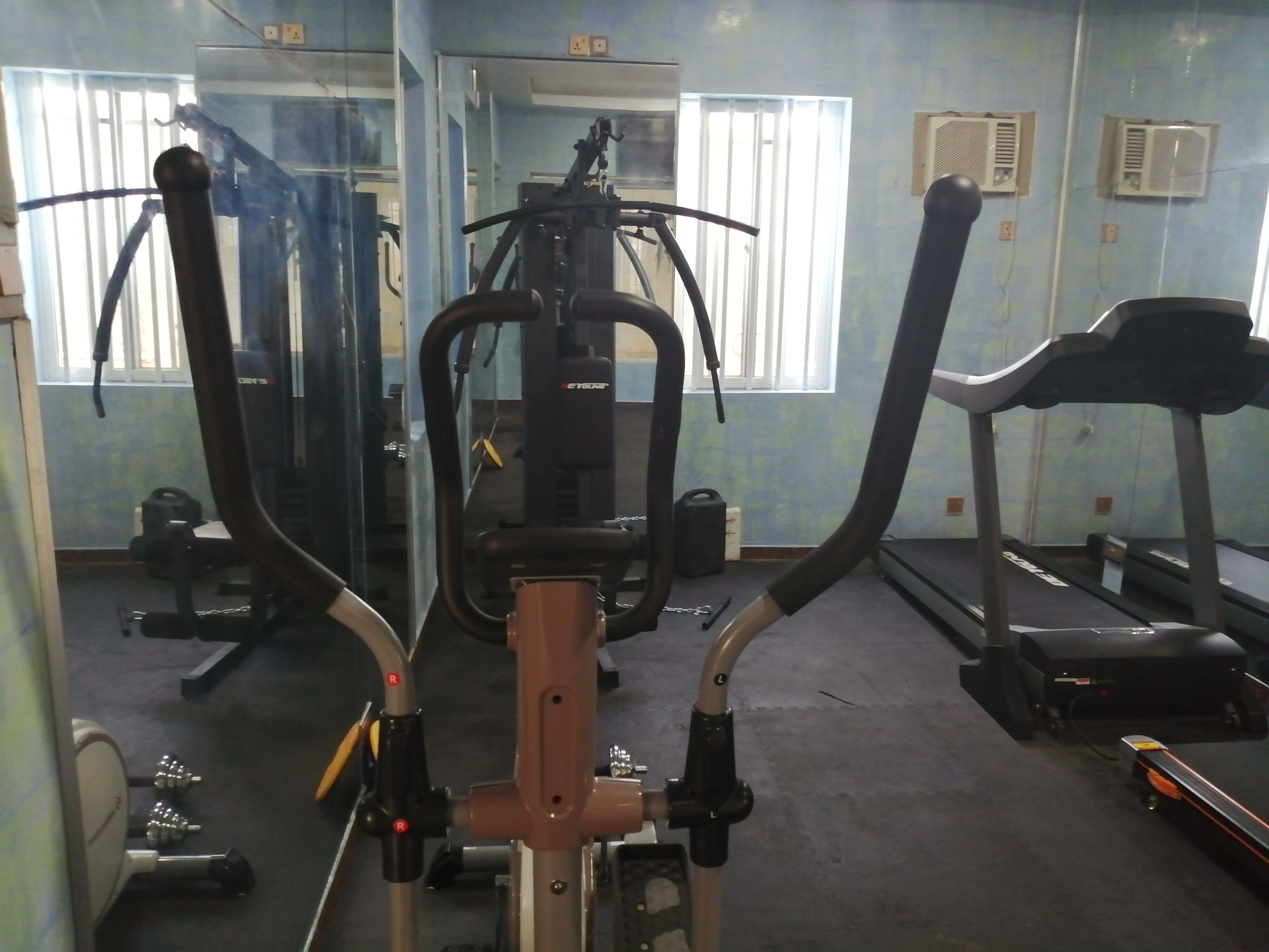 Ett gym med träningsutrustning, inklusive löpband och styrketräningsmaskiner.